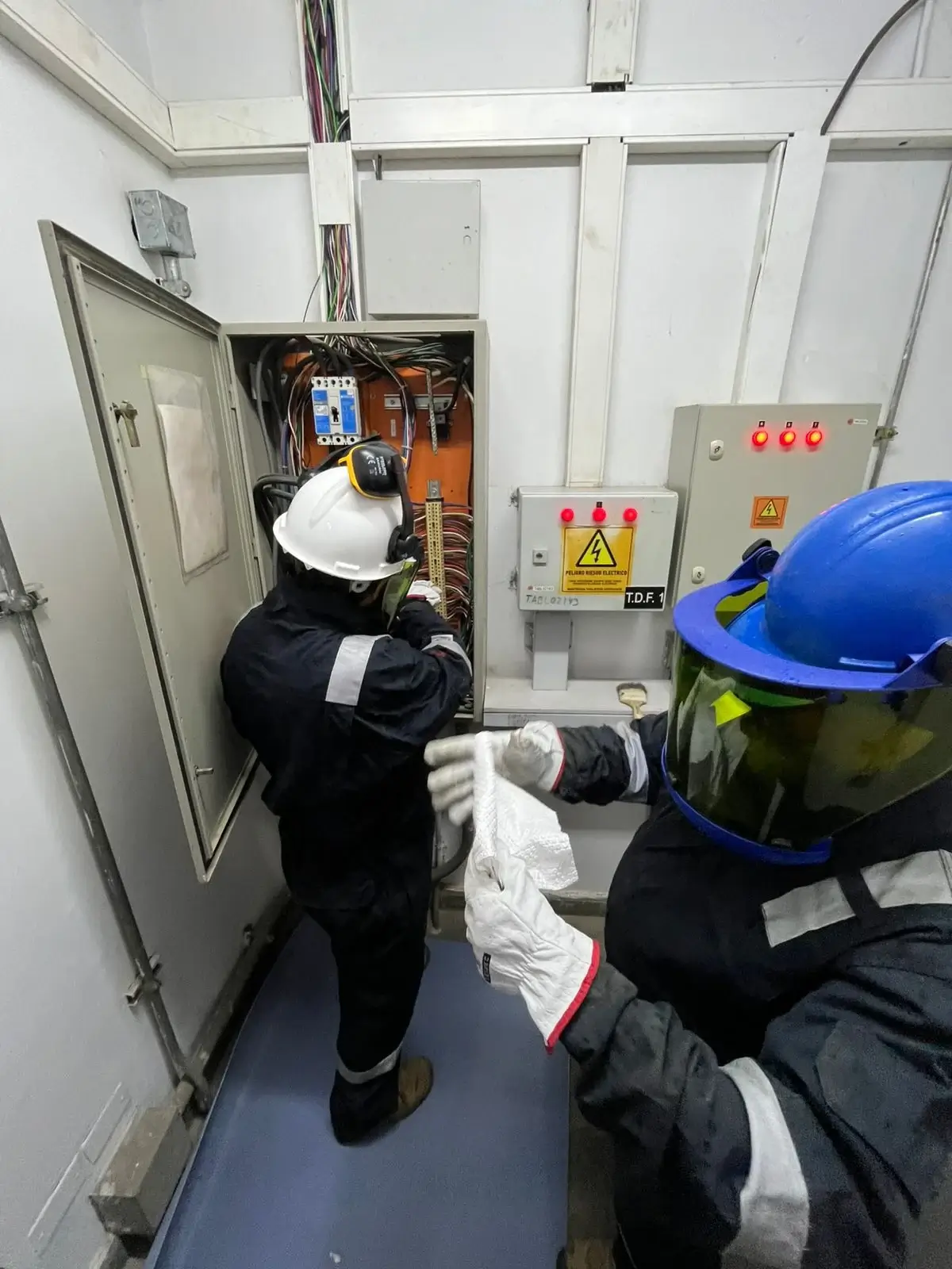 Técnicos de Screwair realizando mantención de tablero eléctrico en terreno industrial
